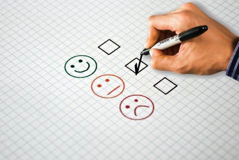 numa folha de papel estão 3 emojis, cada um com uma emoção. Um está contente, o outro normal, o outro triste.